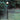 Oluce Fresnel outdoor floor lamp lit in a garden