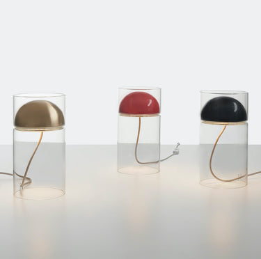 Three Oluce Medusa table lamps in lacquered black with glass cylinders on a white studio background