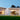 Oluce Otto path lights on a lawn in front of a modern house at dusk