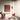 Oluce Pascal floor lamp beside a red chair and a terracotta table in a pale room
