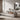 Oluce Pascal floor lamp behind a grey sofa with a round mirror in a living room