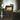 Oluce Plume 221 table lamp beside an armchair in a living room