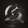 Oluce The Globe table lamp in satin nickel with transparent blown glass sphere on a dark studio background