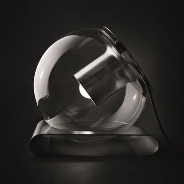 Oluce The Globe table lamp in satin nickel with transparent blown glass sphere on a dark studio background