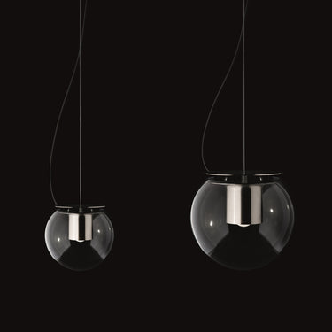 Two Oluce The Globe pendants in satin nickel, small and large, on a dark studio background