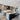 ET2 Pipette glass tube pendants over a kitchen island with gray cabinets and bar stools