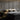 ET2 Reveal tube pendants on either side of a bed against a gray paneled wall