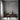 ET2 Rollo tube pendant above a dark dining table in a room with a gray plaster wall