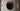 Two Roma wall lights either side of a round dark mirror on a pale paneled wall