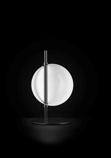 Oluce Superluna table lamp in black with a glowing rotating hemisphere on a black stem