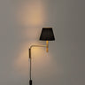 BC Swing Aram Wall Sconce with black ribbon shade and plug-in installation for modern bedrooms and reading spaces