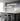 ET2 Sonata linear pendants over a dark marble kitchen island with black stools