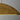 Bau 50 linear pendant light in Natural Brass, shown in a modern kitchen setting with high ceilings.