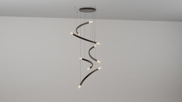 Trace Free Fall 5 chandelier, five curved bronze strands with glass shades stepping down in a vertical cascade, studio view