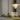 Nimbus chandelier above a cream curved sofa and a green rug against a gray wall