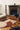 Bijoux Précieux wool rug in Brown, styled in a room