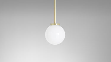 Mezzo pendant with a white opal glass ball on a satin brass rod, studio view