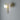Big Bulb wall light in polished brass with a glowing opal globe on a dark wall