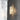 Whistler wall light glowing on a dark tiled wall beside white marble