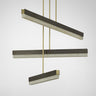 Artes Collective pendant in bronze with satin brass details, three alabaster bars hung at staggered heights, studio view