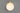 Close-up of a Mezzo opal glass globe on a satin brass backplate against a grey wall