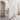 Artes floor lamp, a lit column of alabaster, beside a staircase in a pale room with an arched doorway
