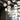 Cluster of white Graypants Scraplights cardboard pendants hanging at varied heights in a tall loft space