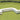 White Arc and Dash modules forming a J-shaped bench on a putting-green lawn