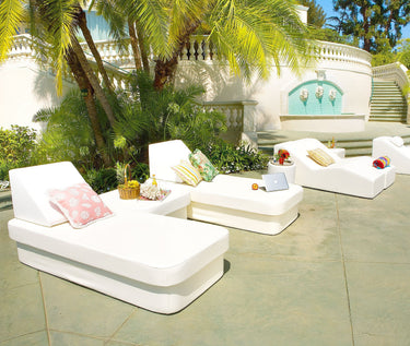 White Stand corner ottoman set beside a Cot twin daybed with a pink pillow on a sunlit terrace with palms