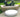 Low white Footnote oval pad on a stone terrace beside a reclining bronze sculpture