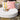 White oval floor pad with striped and pink patterned pillows on a stone patio