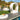 White Pod circle lounge on a pool deck with an oval ottoman and lounge pieces nearby