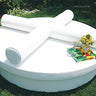 Two white Roll bolsters crossed on a round Sun Pad on a lawn with a tray and flowers