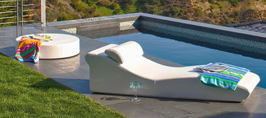 Surf lounge with its pillow beside a pool