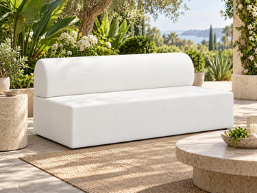 Zig Duo continuous-back bench in white vinyl on a garden terrace, with a stone side table and olive trees behind