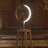 Marcel by Cyclampa glowing at night, a ring of light on an oak stool