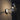 Oluce The Globe wall lamp lit against a dark wall casting warm light