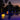 Smart & Green Flatball lamps glowing yellow floating in a pool at dusk with palm trees