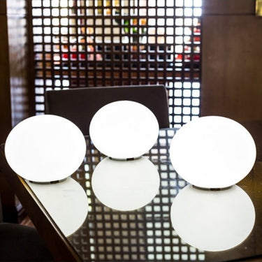 Four Smart & Green Flatball XXS lamps glowing white on a mesh-top table