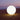 Smart & Green Globe white glowing sphere lamp on a sandy beach at dusk
