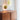 Chrona 10 in vertical brass dish pendant glowing in a room