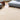 Volute Round wool rug in Beige, styled in a room