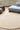 Volute Round wool rug in Beige, styled in a room