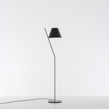 Modern LED floor lamp - Artemide La Petite - casting soft, ambient light in a bedroom, Black finish