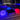 Violet, blue and red glowing Cube lamps around a dark coffee table beside a pool at night