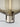 Close-up of the Flar table lamp's honey-colored glass shade and elegant terra finish steel base.