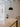 Black ceramic pendant lamp hanging above modern dining table with black canopy