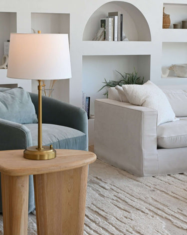 Alexis rechargeable lamp in antique brass with linen shade in a living room