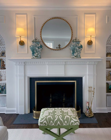 Emily rechargeable wall sconces in antique brass on each side of a fireplace mirror