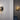 Two Pendulum wall lights with smoked glass shades and brass discs on walls in a room